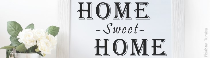Schild Home-Sweet-Home neben wei&szlig;er Blume